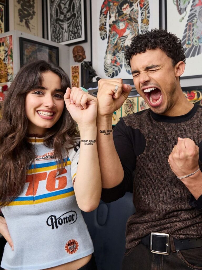Airbrush artist applying custom film title tattoo on actor's wrist at London tattoo Parlour